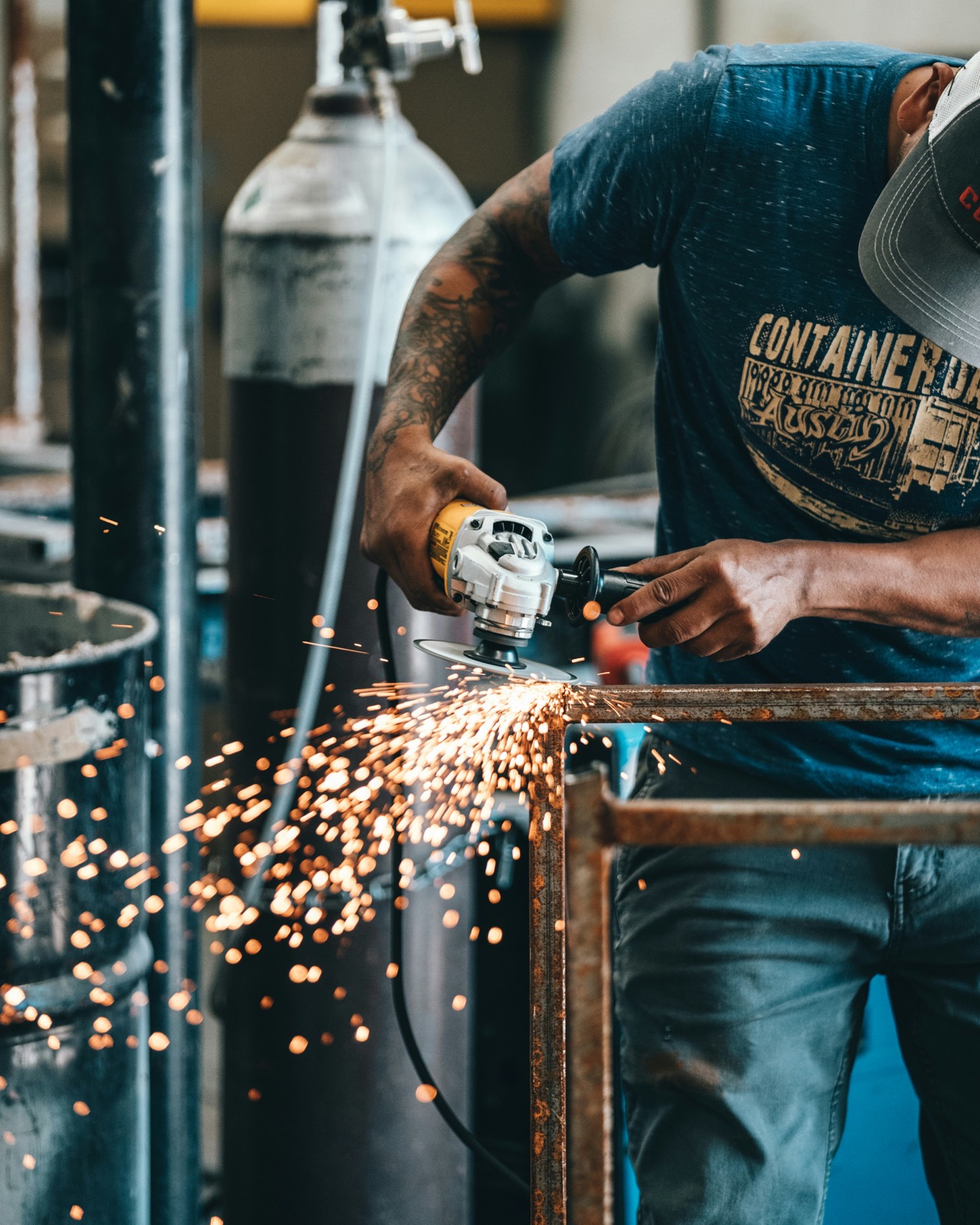 Steel worker using an angle grinder on a metal frame