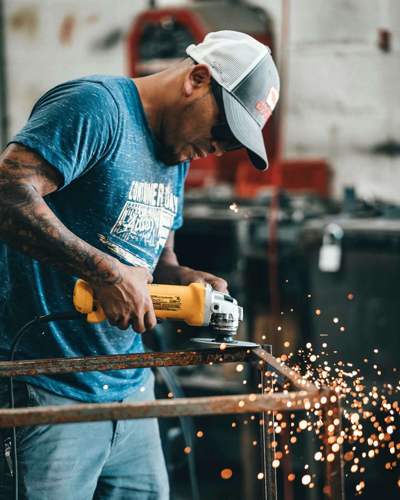 Fabricator grinding a steel frame with sparks flying